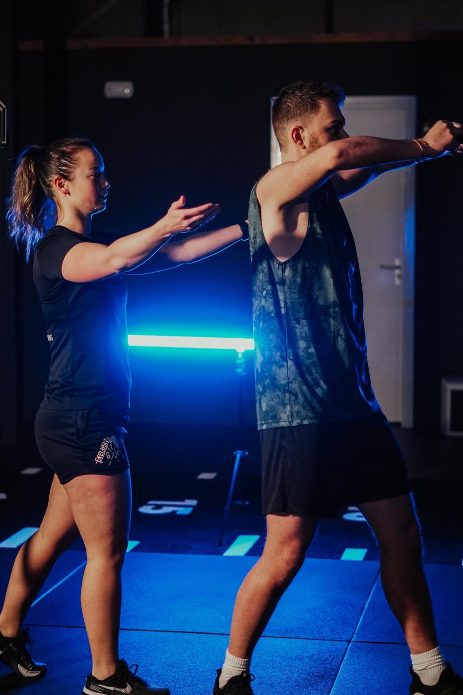 Coach geeft uitleg bij een oefening met een kettlebell