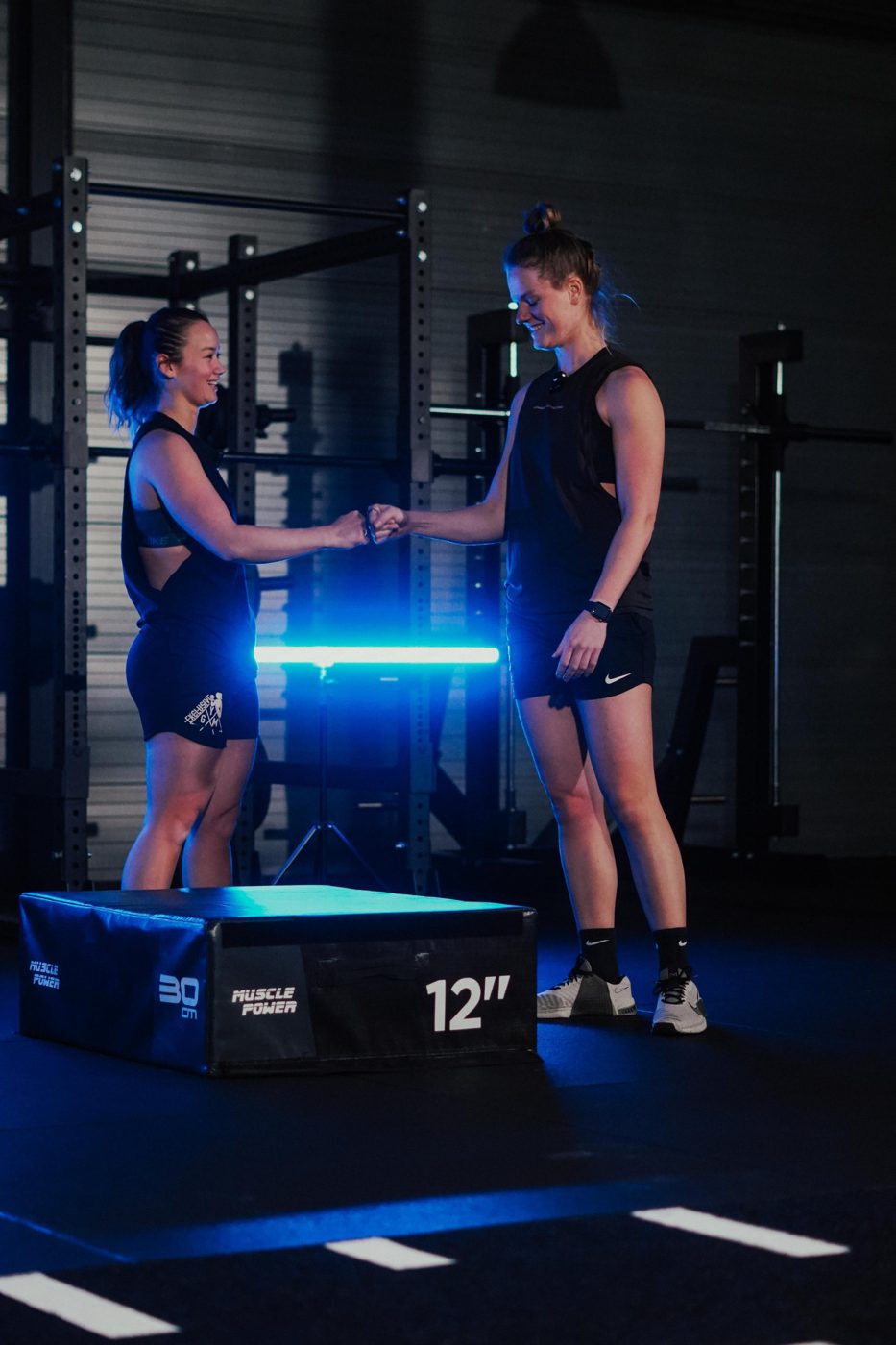 Twee sporters geven elkaar een boks na een duo training