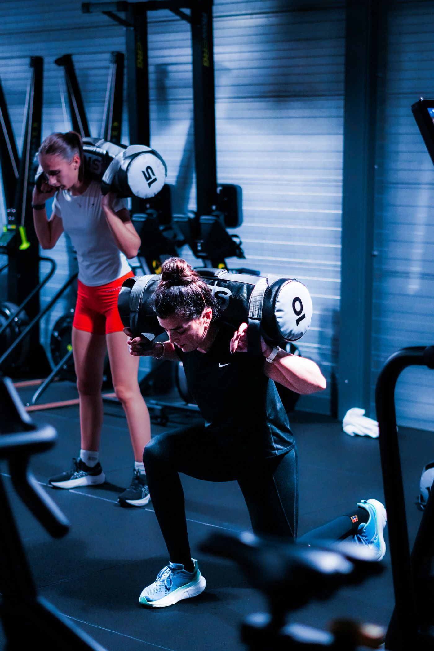 Twee collega’s doen samen sandbag lunges