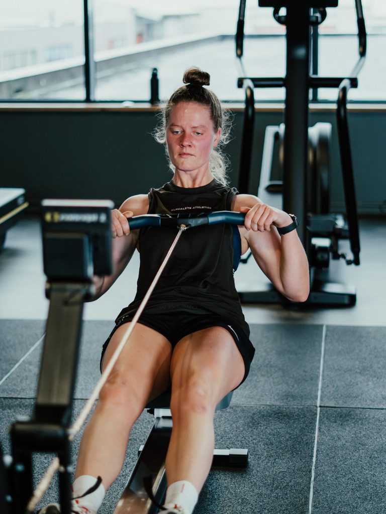 Sporter traint geconcentreerd op de roeimachine in de studio