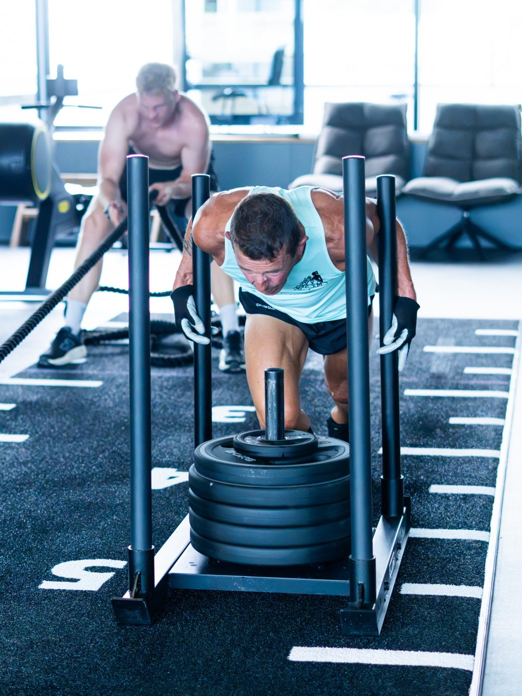 Sled push en battle ropes tijdens een HYROX-training